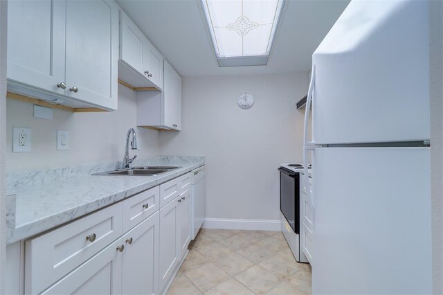 kitchen with sink, light stone countertops, white appliances, and white cabinets