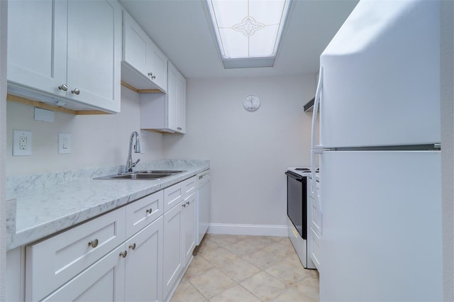 kitchen with a sink, baseboards, white appliances, and white cabinets