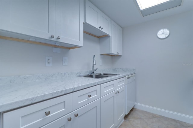 kitchen featuring a sink, light tile patterned flooring, white cabinets, white dishwasher, and baseboards