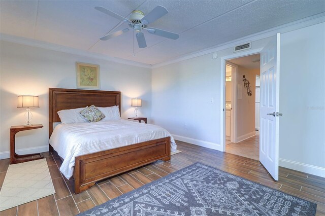 bedroom featuring ornamental molding, a textured ceiling, and ceiling fan