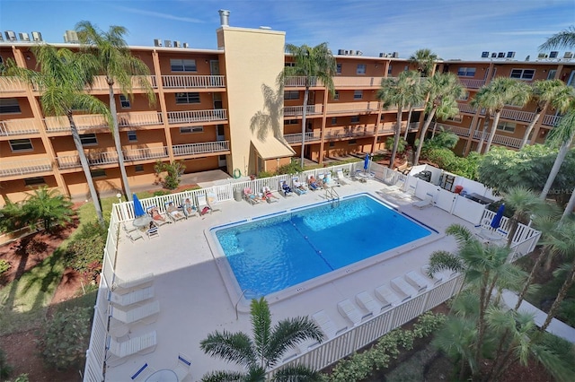 community pool with a patio and fence