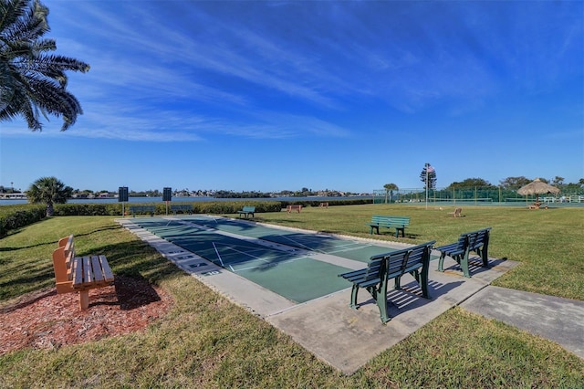 view of property's community featuring shuffleboard and a lawn