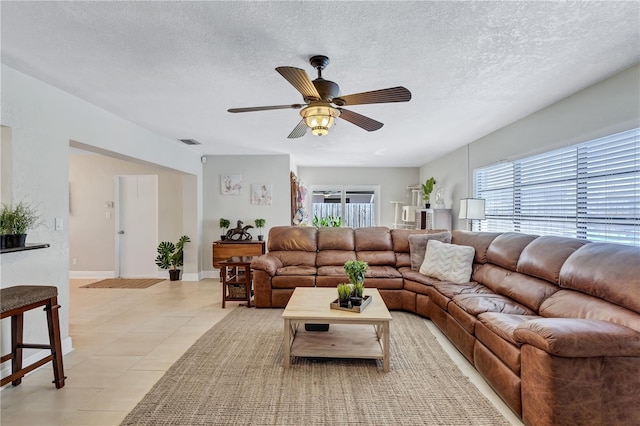 living room featuring a textured ceiling, a healthy amount of sunlight, and ceiling fan