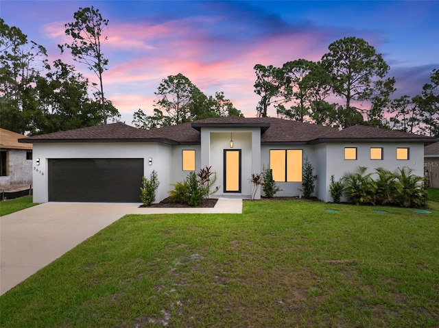 view of front of property featuring stucco siding, concrete driveway, a lawn, and a garage