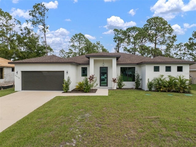 prairie-style home featuring stucco siding, roof with shingles, concrete driveway, a front yard, and an attached garage