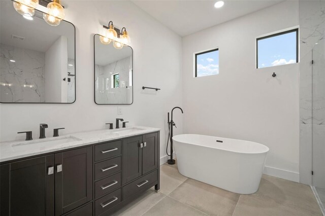 bathroom featuring a tub to relax in, vanity, and tile patterned floors