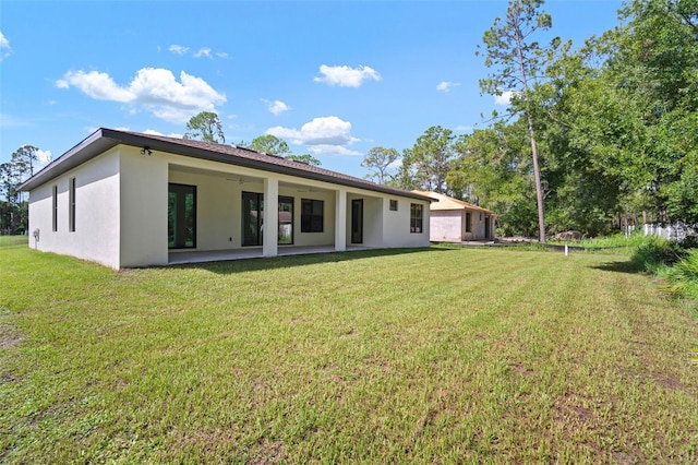 rear view of property with a yard and a patio