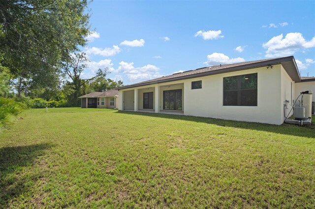 rear view of property featuring a lawn