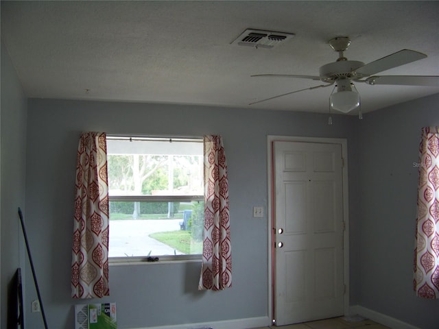 unfurnished room with a textured ceiling and ceiling fan