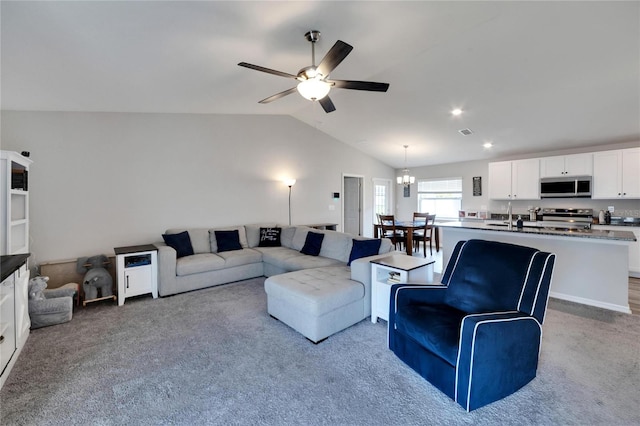 living room with lofted ceiling, ceiling fan, sink, and carpet floors