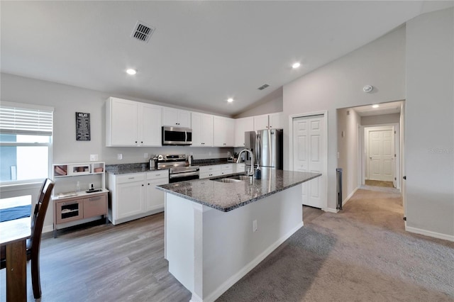 kitchen with white cabinets, light carpet, stainless steel appliances, and sink