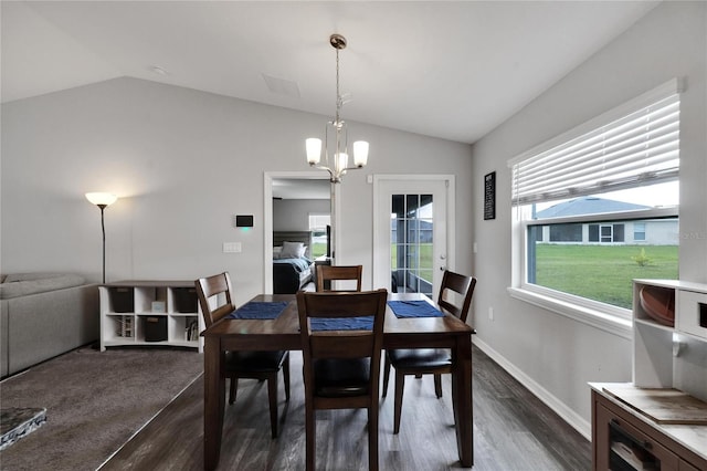 dining area with dark wood-type flooring, vaulted ceiling, and a notable chandelier