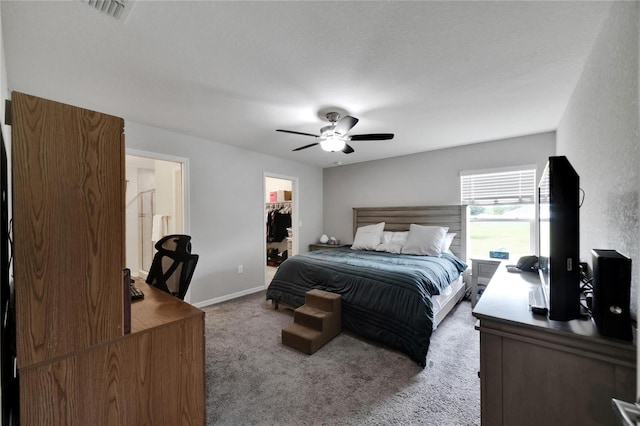 carpeted bedroom featuring a walk in closet, ceiling fan, and a closet