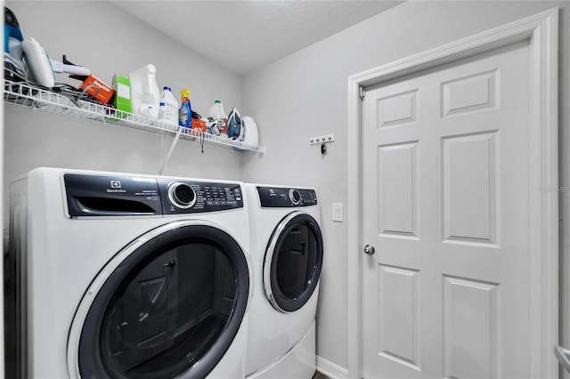 laundry room featuring separate washer and dryer and a textured ceiling