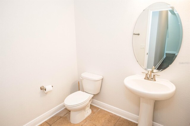 bathroom with toilet and tile patterned floors