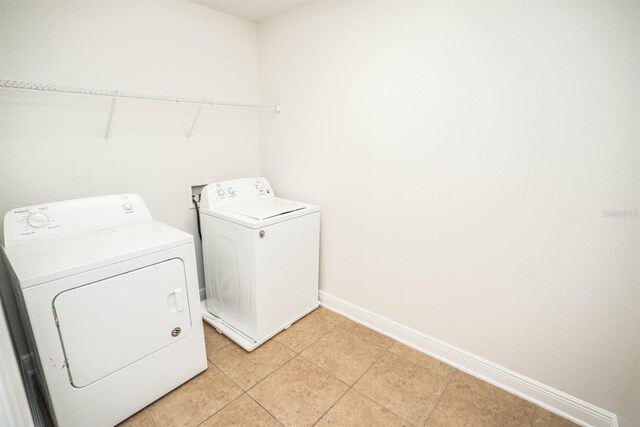 laundry area featuring separate washer and dryer and light tile patterned floors