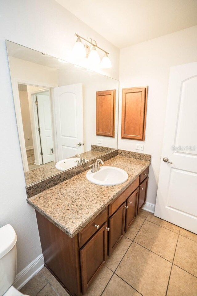 bathroom featuring vanity, toilet, and tile patterned floors