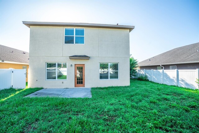 back of property featuring a yard and a patio