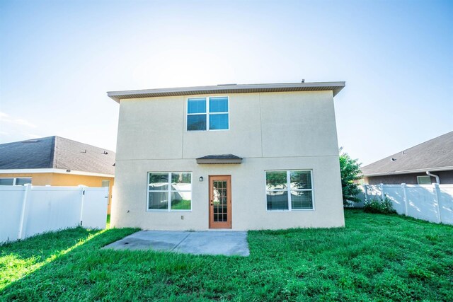 rear view of property featuring a yard and a patio