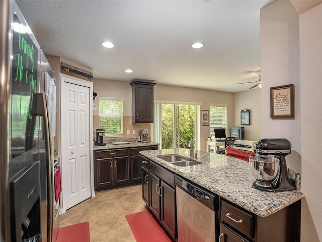 kitchen featuring ceiling fan, stainless steel appliances, dark brown cabinetry, and sink