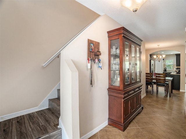 hall featuring a chandelier and tile patterned floors