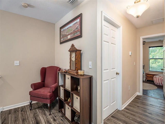 sitting room featuring a textured ceiling and dark hardwood / wood-style flooring