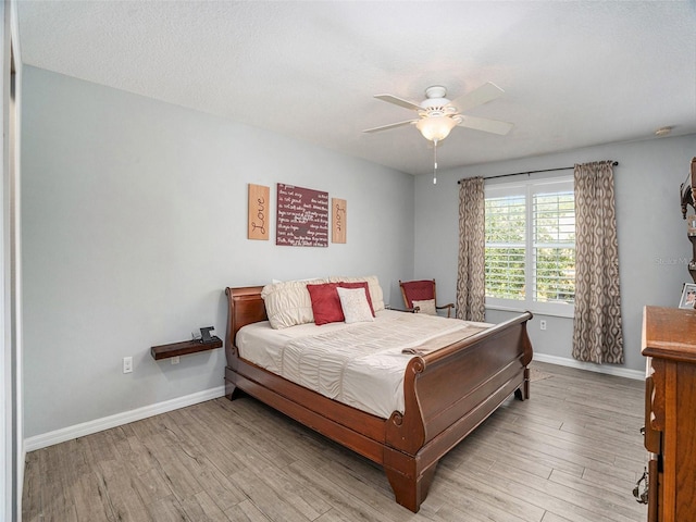 bedroom featuring a textured ceiling, light hardwood / wood-style flooring, and ceiling fan