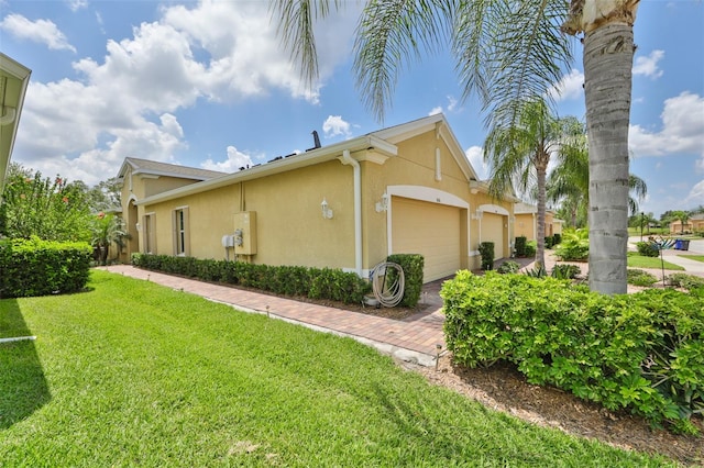 view of side of property featuring a lawn and a garage