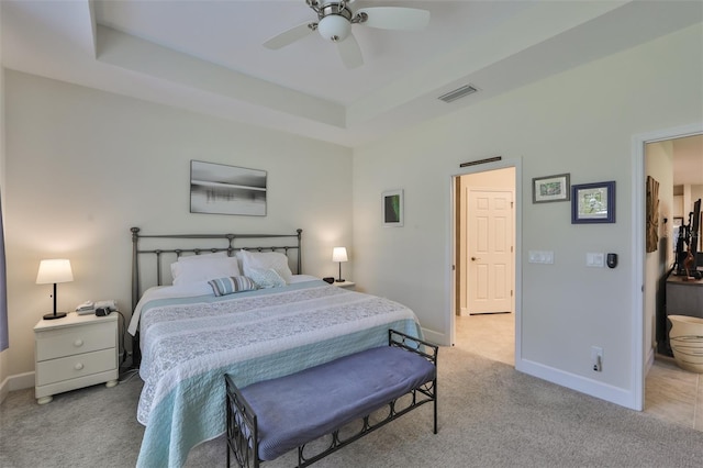 carpeted bedroom with a raised ceiling and ceiling fan