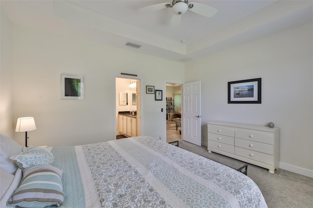 carpeted bedroom featuring ensuite bath and ceiling fan