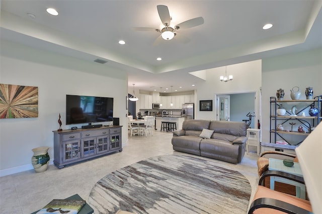 living room with ceiling fan with notable chandelier and light tile patterned floors