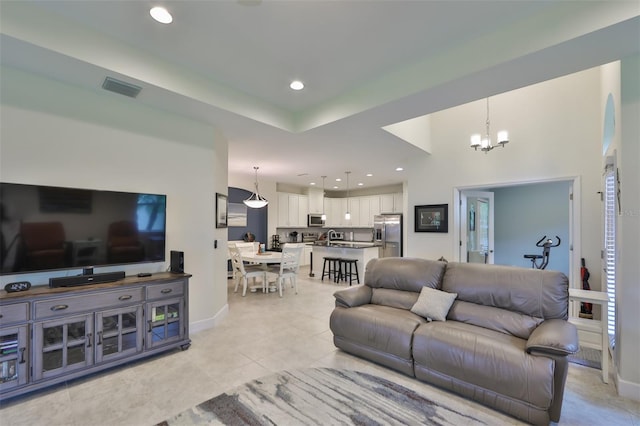 tiled living room with sink and a notable chandelier