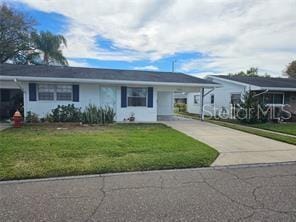 ranch-style house featuring a front lawn and a carport