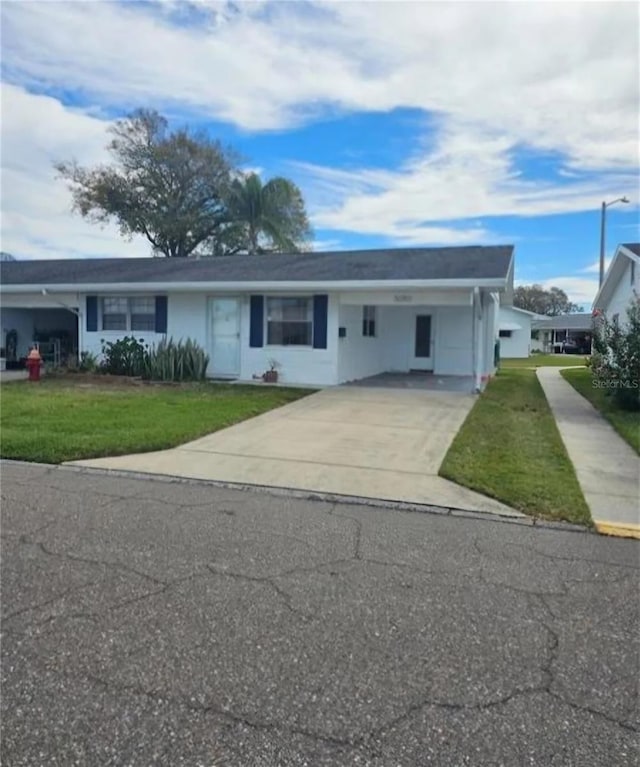 ranch-style home featuring a carport and a front yard