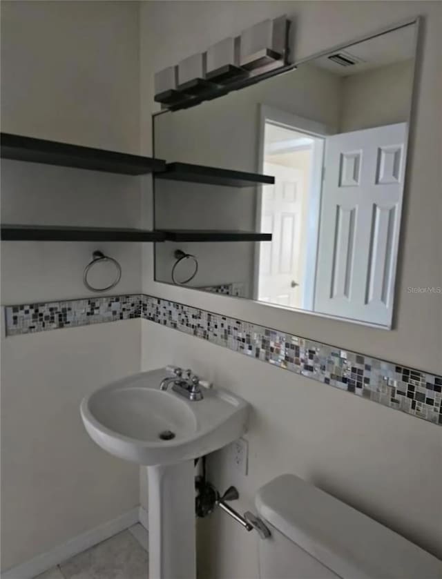 bathroom featuring toilet and tile patterned floors