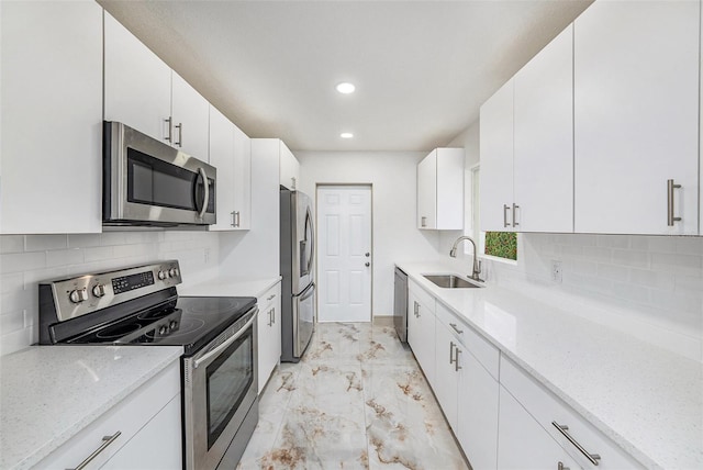 kitchen featuring light stone countertops, white cabinets, sink, and stainless steel appliances