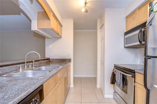 kitchen featuring light brown cabinets, a sink, a textured ceiling, light tile patterned floors, and stainless steel appliances