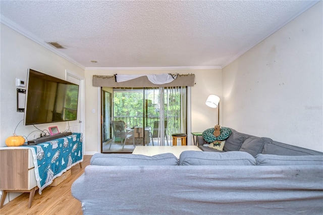 living area featuring visible vents, crown molding, a textured ceiling, and wood finished floors