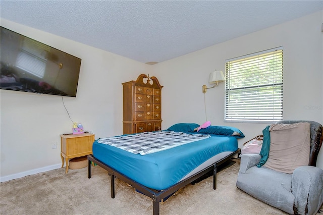 bedroom featuring baseboards, a textured ceiling, and carpet