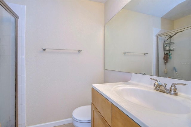 full bathroom with toilet, vanity, baseboards, and tiled shower