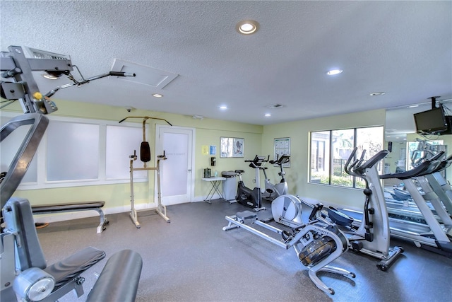 gym with recessed lighting, visible vents, and a textured ceiling