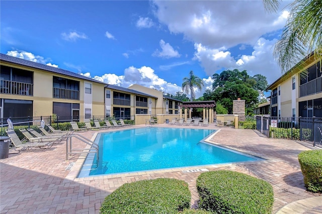 pool featuring a pergola, fence, and a patio