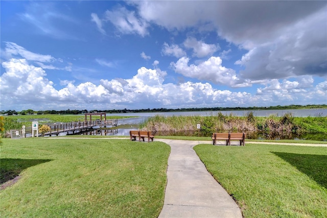 view of home's community featuring a lawn and a water view