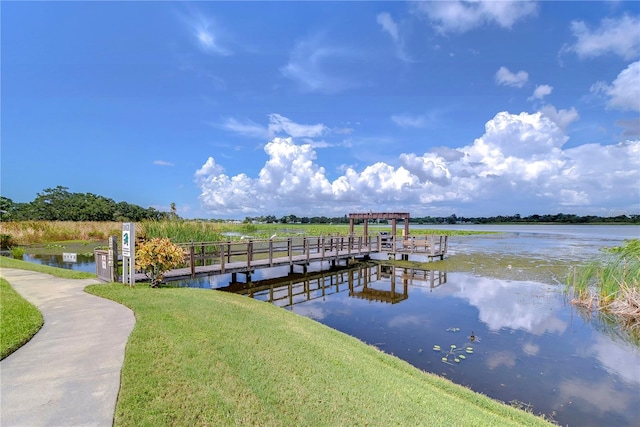 dock area featuring a water view and a lawn