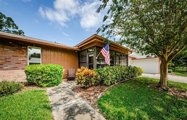 ranch-style house featuring a garage and a front lawn