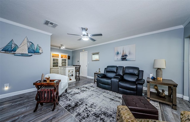 living room with ornamental molding, dark wood-type flooring, and ceiling fan