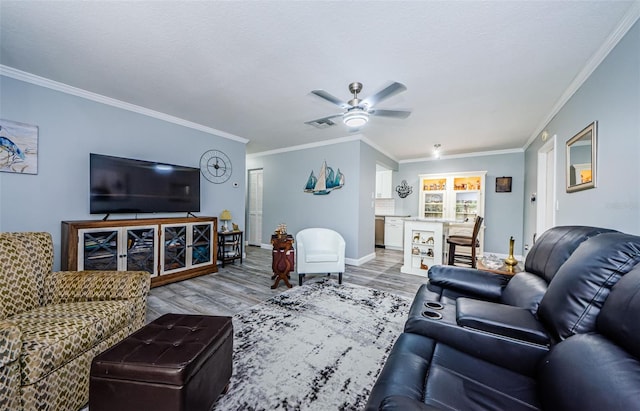 living room with ceiling fan, hardwood / wood-style flooring, and ornamental molding