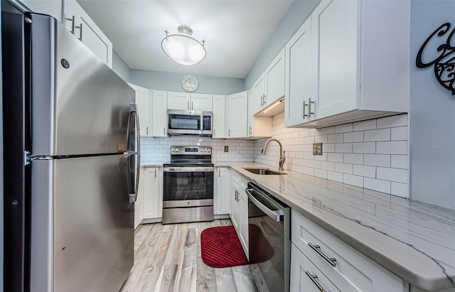 kitchen featuring light wood-type flooring, white cabinetry, sink, and stainless steel appliances