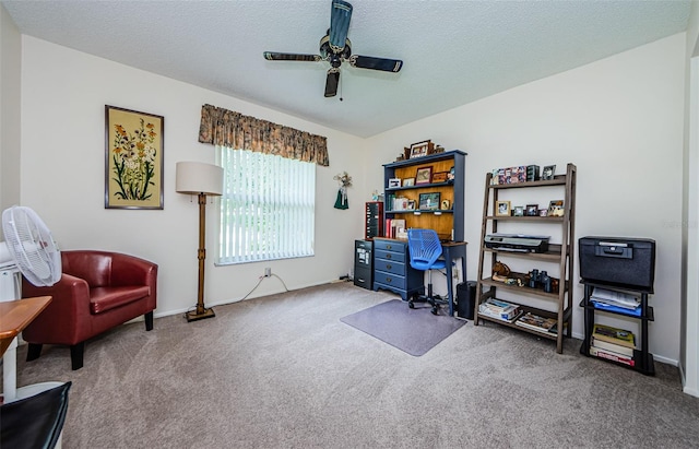 carpeted office space featuring ceiling fan and a textured ceiling