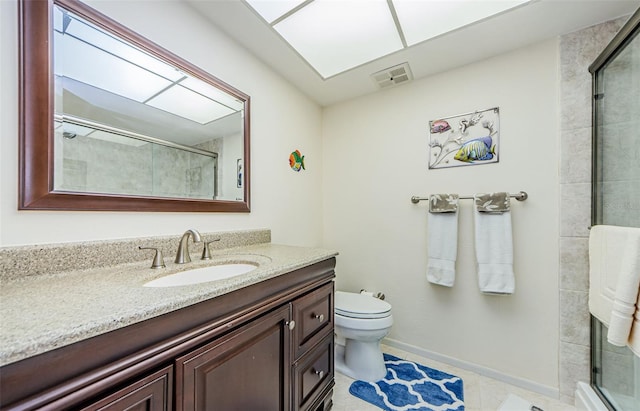 bathroom with vanity, toilet, a shower with door, and tile patterned floors